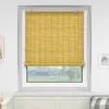 A yellow bamboo roller blind is installed on a window. Produktbild-Vorschau
