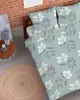 A bedroom scene with a bed dressed in floral bedding. Produktbild-Vorschau