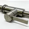 A close-up shot of a brushed stainless steel faucet handle and part of the faucet body. Produktbild-Vorschau