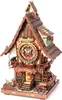 A detailed 3D wooden puzzle model of a cuckoo clock, designed with intricate gears and decorative elements, set against a white background. Náhľad obrázku produktu