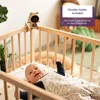 A baby monitor attached to a crib with a baby inside. Produktbild-Vorschau
