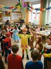 Children in costumes celebrating a party in a classroom. Produktbild-Vorschau