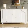 A white sideboard with decorative doors stands in a room with a painting on the wall and a lamp on top. Produktbild-Vorschau
