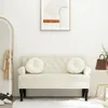 A cream-colored sofa with two round cushions is placed in a room with a mirror and a painting on the wall. Náhled obrázku produktu