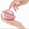 Hands holding and opening a pink jar of hair mask. Produktbild-Vorschau