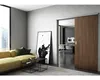A modern living room with a yellow sofa, abstract art, and a sliding door leading to a kitchen. Náhled obrázku produktu