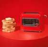 A red toaster sits next to a stack of buttered toast on a red surface against a red background. Voir les images du produit