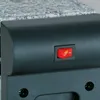 A close-up view of a red power switch on a black appliance. Produktbild-Vorschau