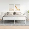A bedroom scene with a white bed frame, pillows, and a rug. Náhľad obrázku produktu