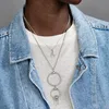 A person wearing a denim jacket and a white t-shirt, layered with multiple silver necklaces. Produktbild-Vorschau