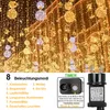 A street decorated with many warm white and gold string lights and decorative orbs. Náhled obrázku produktu