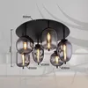 A close-up view of a modern ceiling light fixture with multiple glass shades. Náhľad obrázku produktu