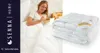 A woman is eating cereal in bed with a duvet. Podgląd zdjęcia produktu