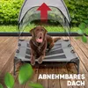 A brown dog is lying on a raised dog bed with a canopy, outdoors on a wooden deck. Produktbild-Vorschau