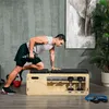 A man is performing a dumbbell row exercise on a wooden weight bench in a home gym setting. Náhľad obrázku produktu