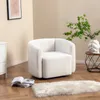A white sherpa armchair is placed on a wooden floor next to a small side table with a vase and plant, and a stack of books. Podgląd zdjęcia produktu