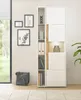 A modern living room or home office setting with a tall white and wood tone cabinet, framed artwork on the wall, and a leather messenger bag on the floor. Produktbild-Vorschau