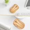 Two wooden computer mice are placed on a white desk next to a keyboard and a plant. Produktbild-Vorschau