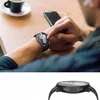 A person is using a smartwatch while sitting at a table with a cup of coffee and a smartphone. Voir les images du produit