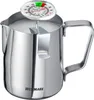 A silver milk frothing pitcher with a thermometer on top, filled with milk. Náhľad obrázku produktu