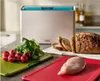 A kitchen counter with a cutting board set, radishes, bread, and chicken. Náhľad obrázku produktu