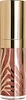 A close-up product shot of a makeup product with a gold cap and a glass bottle featuring a zebra-like pattern. Produktbild-Vorschau