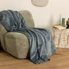A blue plaid draped over a green armchair next to a small gold side table with a book and decorative items. Podgląd zdjęcia produktu