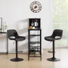 Two black bar stools are placed on either side of a black bar cart with wine bottles and glasses. Produktbild-Vorschau