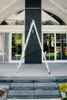 An aluminum ladder is set up on a stone patio in front of a modern house with large windows. Produktbild-Vorschau