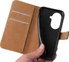 A hand holding a black phone case, with the inside of a brown wallet-style phone case visible. Produktbild-Vorschau
