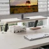 A desk setup with a monitor, keyboard, books, and a notebook, placed near a window with blinds. Náhled obrázku produktu