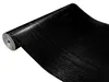 A roll of black wood-grain contact paper is shown on a white background. Produktbild-Vorschau