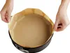 Hands lining a round cake pan with parchment paper. Anteprima dell’immagine prodotto