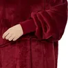 A close-up view of a person's arm wearing a red hoodie blanket with sleeves. Produktbild-Vorschau