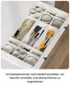 An open kitchen drawer filled with cutlery and small bowls, organized with dividers. Voir les images du produit