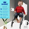 A young child sits on a toilet training seat with a step, positioned next to a toilet. The image includes text overlays highlighting product features. Produktbild-Vorschau