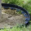 A black garden border is installed around the base of a tree, separating the soil from the surrounding grass. Podgląd zdjęcia produktu