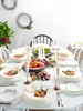 A beautifully set dining table with plates of food, champagne glasses, and candles, suggesting a festive meal or gathering. Voir les images du produit