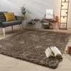 A cozy living room scene with a plush rug, armchair, and decorative items. Produktbild-Vorschau