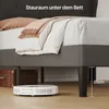 A robot vacuum cleaner is cleaning under a bed with a suitcase to the side. Náhled obrázku produktu