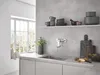 A modern kitchen sink area with a wall-mounted faucet, dishes on a shelf, and a window in the background. Anteprima dell’immagine prodotto