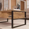 A close-up view of a wooden coffee table with a black metal frame, set in a living room with a rug and a sofa visible in the background. Voir les images du produit