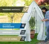 A woman is zipping up a white tent-like structure in a garden setting, with potted plants inside. Produktbild-Vorschau