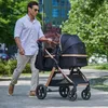 A man is pushing a stroller on a paved path in a park. Náhled obrázku produktu