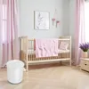 A nursery room with a crib, curtains, and a trash can. Produktbild-Vorschau