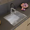 A modern kitchen sink with a black faucet and a bowl of figs in the background. Produktbild-Vorschau