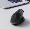 A black ergonomic mouse is placed on a white desk next to a laptop. Produktbild-Vorschau