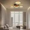 A modern living room with a sectional sofa, a large window with blinds, and a contemporary ceiling light. Voir les images du produit