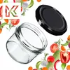 A glass jar and its lid are shown, surrounded by various fresh vegetables and herbs. Anteprima dell’immagine prodotto