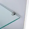 A close-up view of a glass shelf supported by a metal bracket attached to a white wall. Produktbild-Vorschau